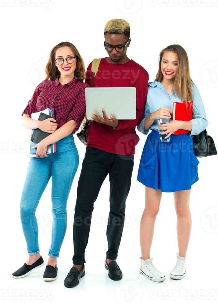 Happy students standing and smiling with books, laptop and bags isolated on white photo