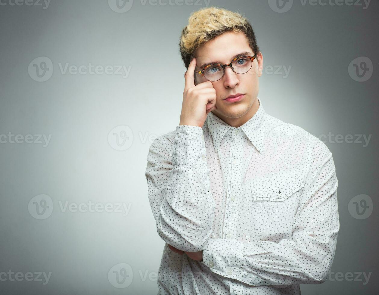 Young man with glasses thinking photo