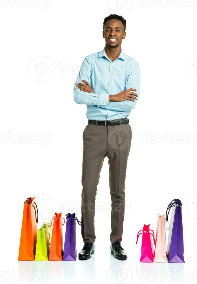 contento africano americano hombre con compras pantalones en blanco antecedentes foto