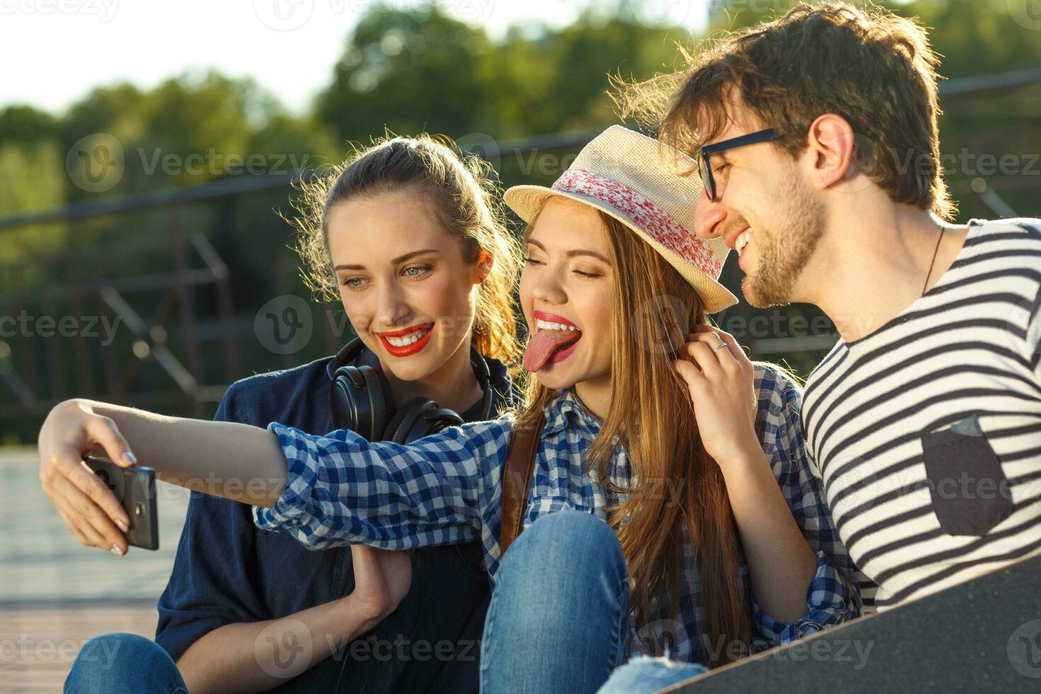 Smiling friends making selfie outdoors photo