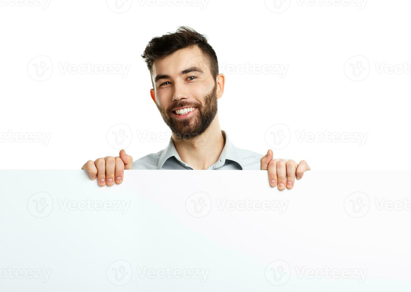 A young bearded man showing blank signboard, isolated over white photo