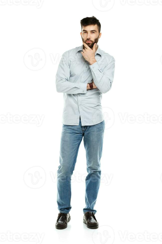 A young bearded man with a serious expression on his face isolated on white photo