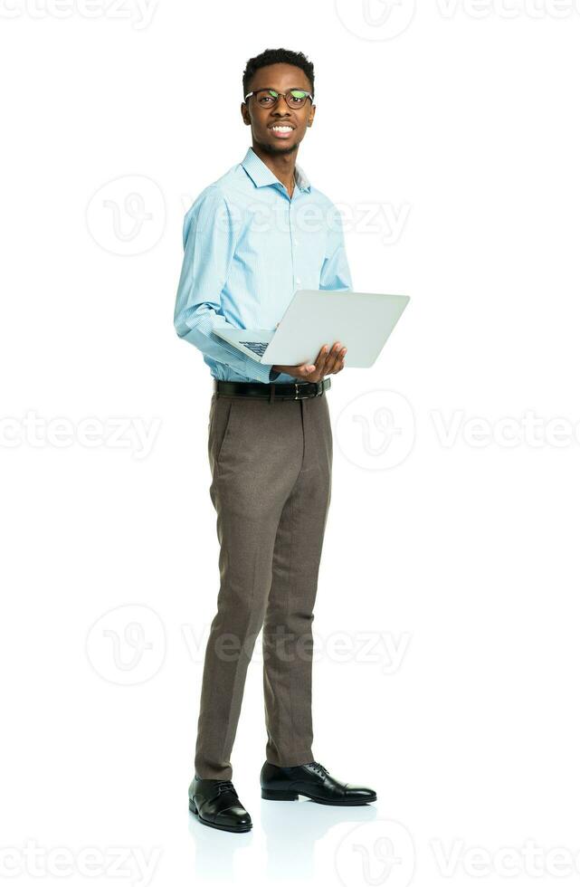 Happy african american college student with laptop standing on white photo