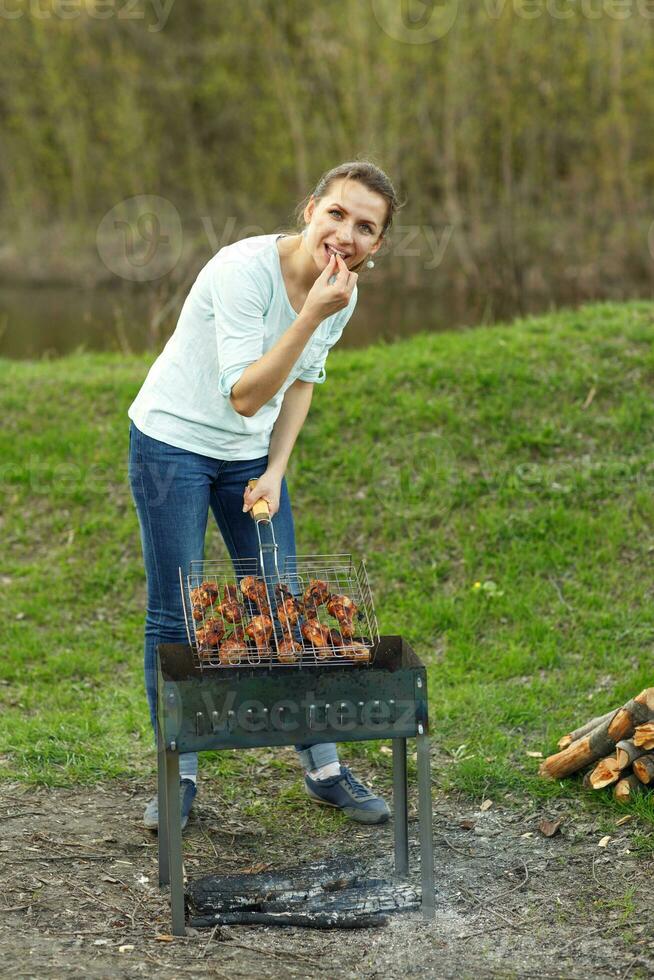 Young girl preparing food on grill photo
