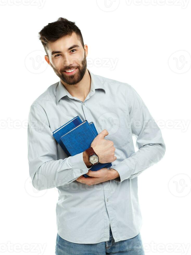 Young bearded smiling man with books in hands on white photo