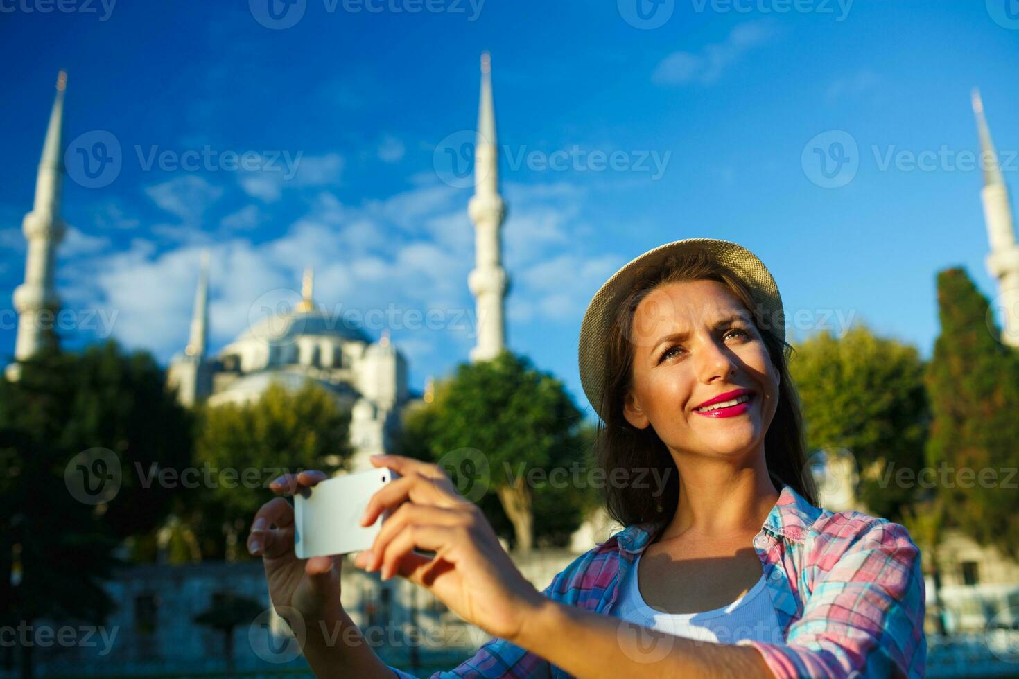 Girl making selfie by the smartphone on the background of the Blue Mosque, Istanbul. Turkey photo