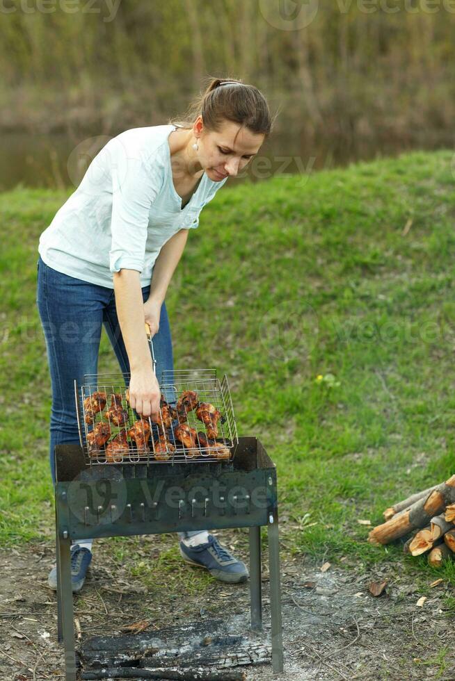 Young girl preparing food on grill photo