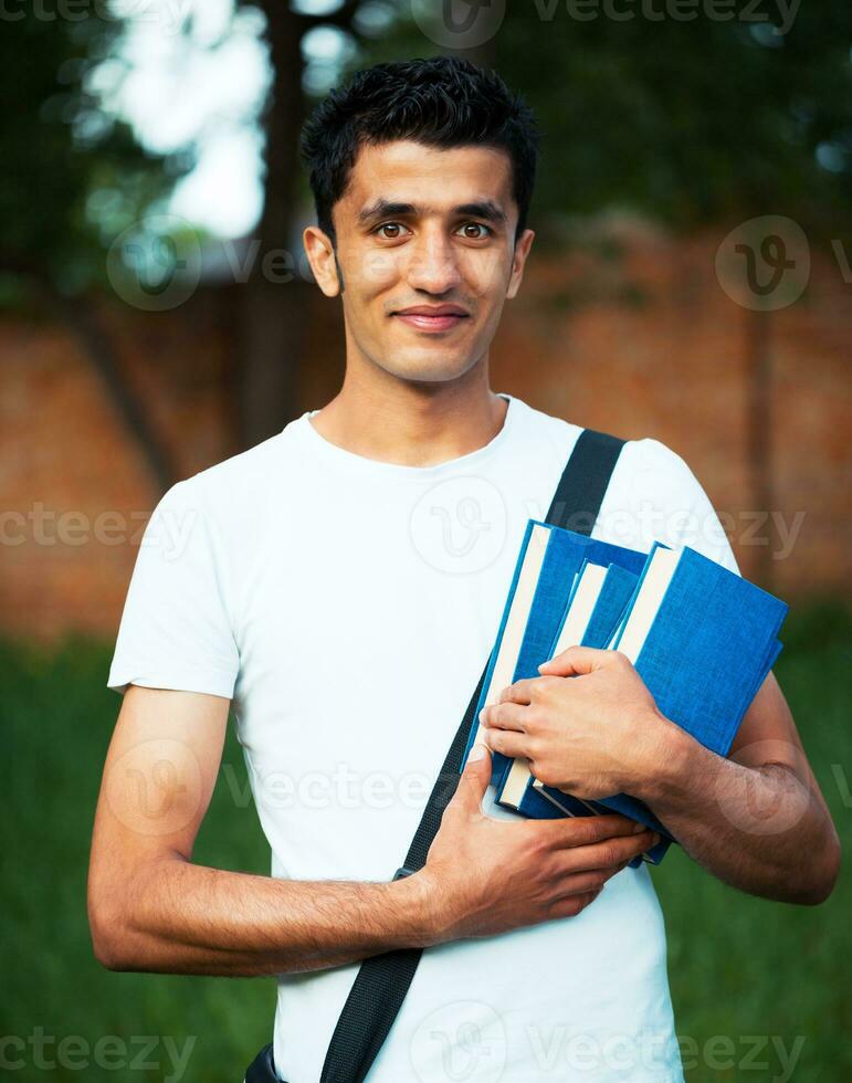 árabe masculino estudiante con libros al aire libre foto