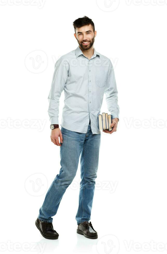 Young bearded smiling man with books in hand on white photo