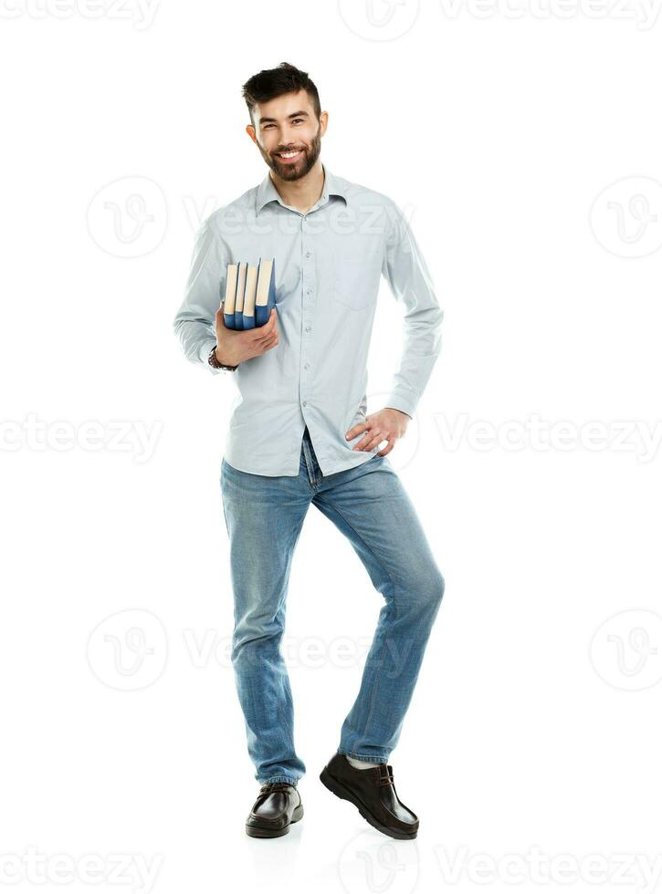 Young bearded smiling man with books in hands on white photo