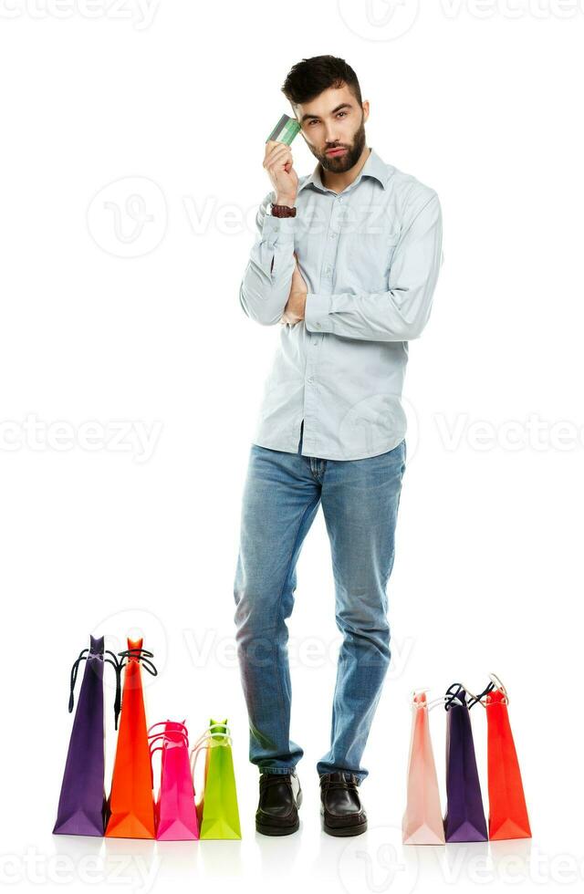 Handsome smiling man with shopping bags and holding credit card photo