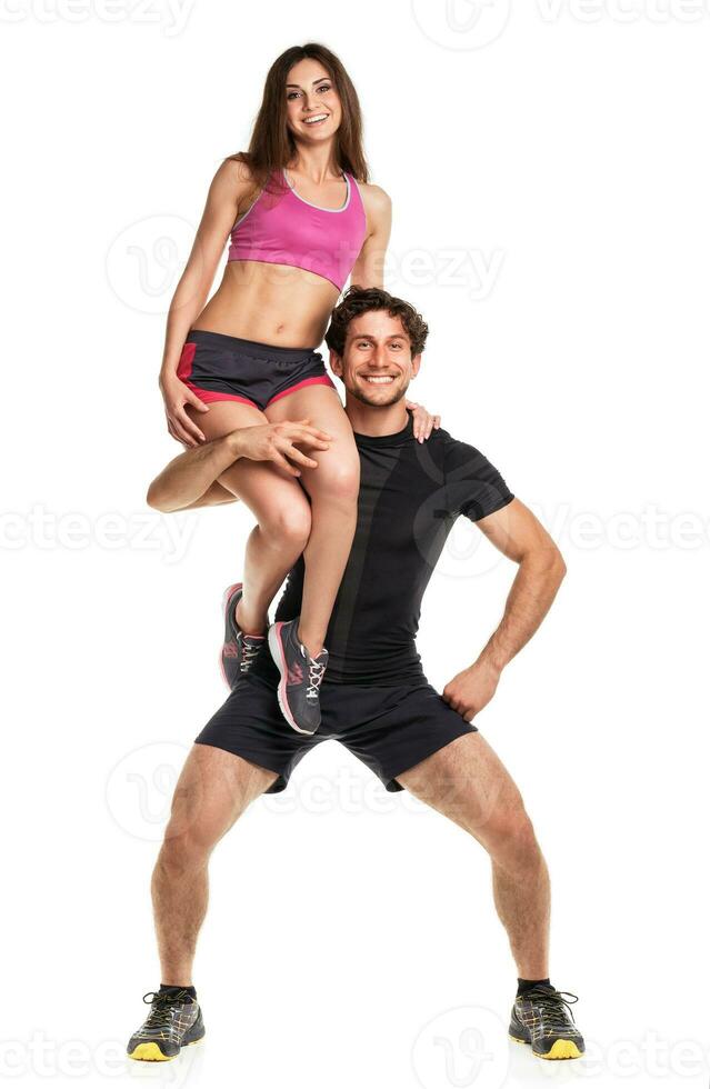 Sports guy holds on shoulder a girl on a white photo