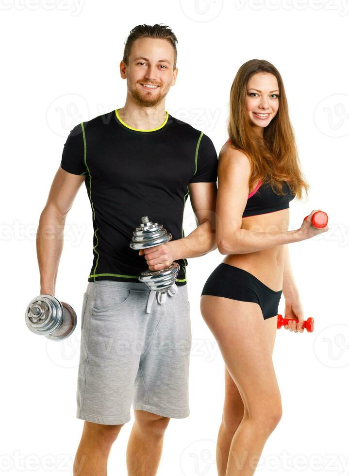 Sport couple - man and woman with dumbbells on the white photo