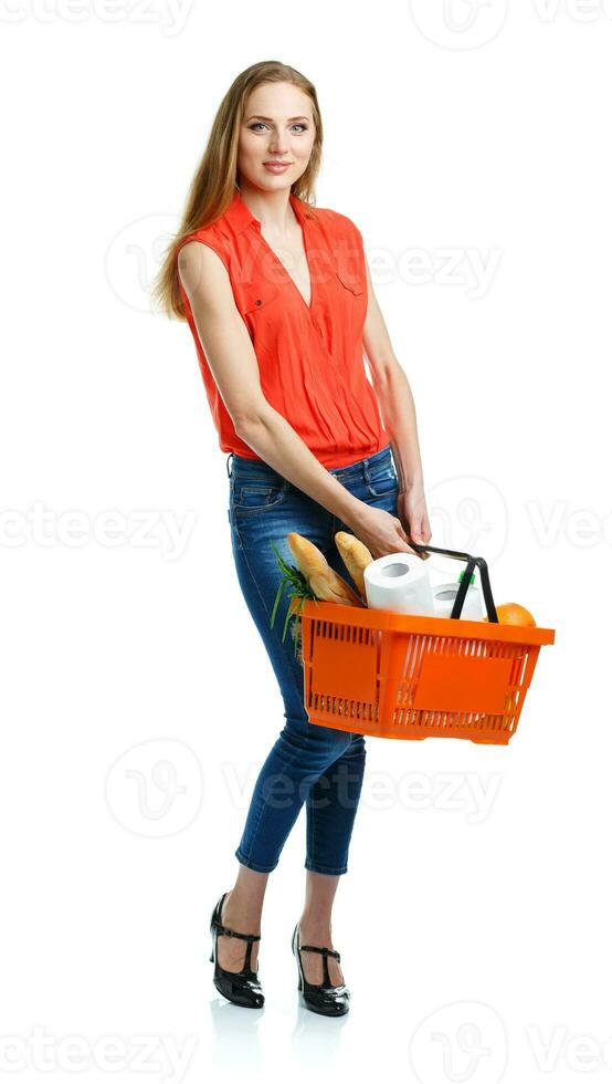 Happy woman holding a basket full of healthy food. Shopping photo