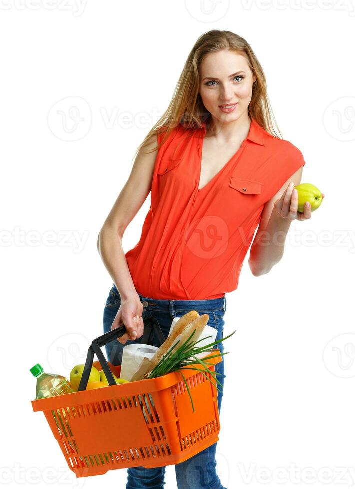 Happy woman holding a basket full of healthy food. Shopping photo