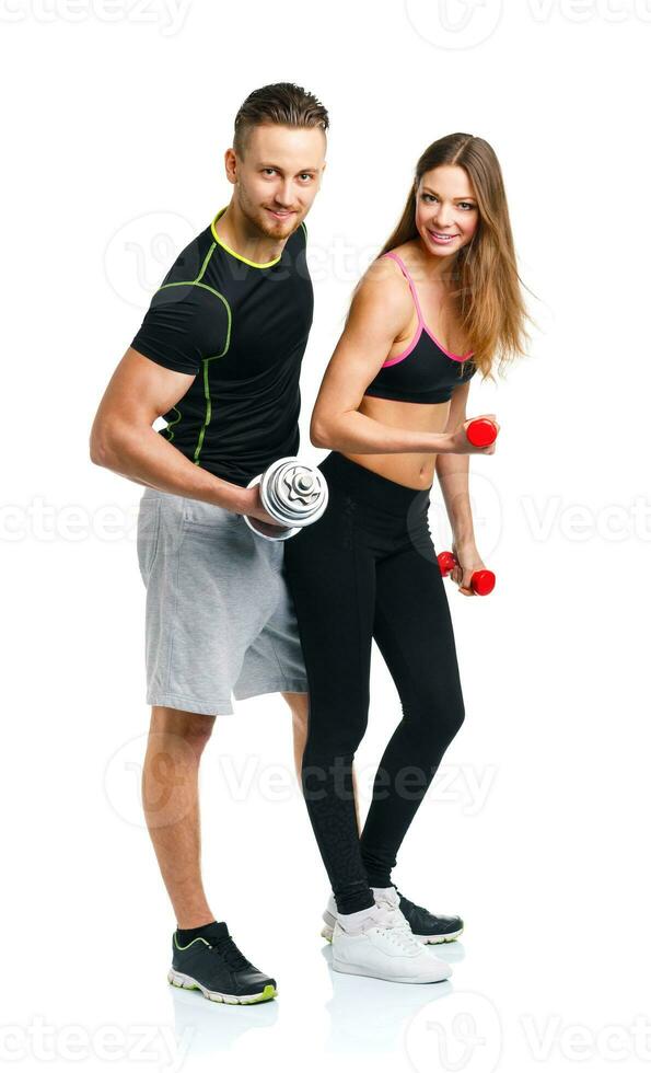 Sport couple - man and woman with dumbbells on the white photo