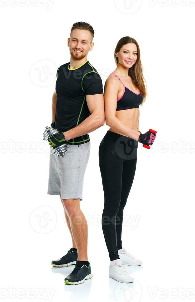 Sport couple - man and woman with dumbbells on the white photo