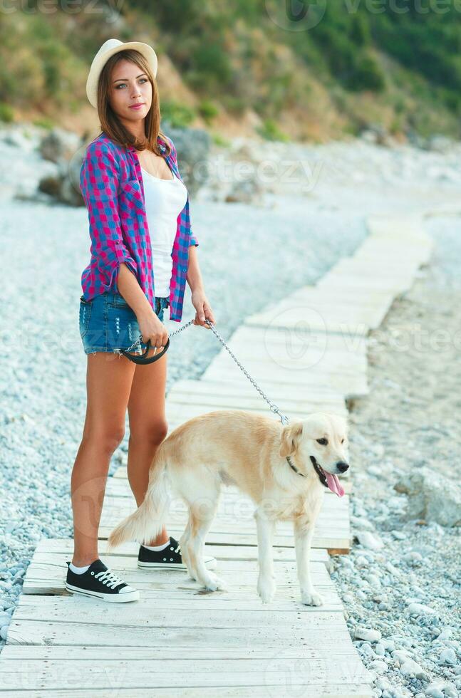 Woman with a dog on a walk on the beach photo