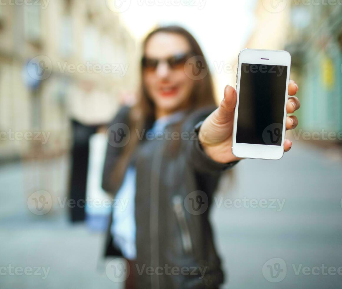 Online shopping concept - beautiful woman with shopping bags and smart phone in the hands photo