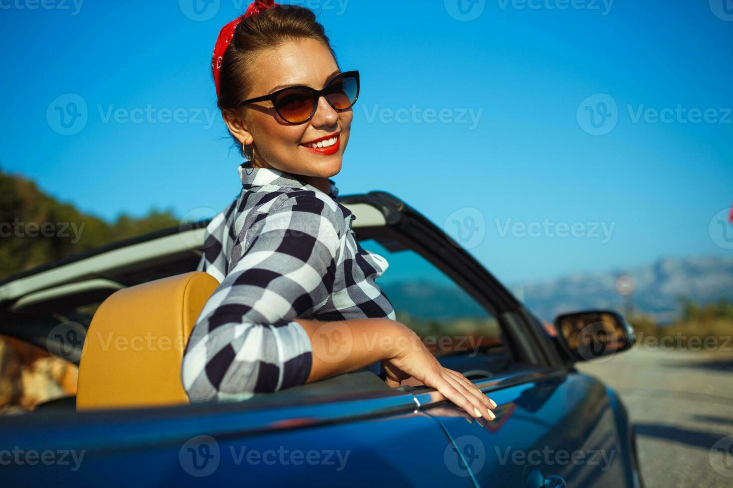 hermosa alfiler arriba mujer sentado en cabriolé, disfrutando viaje en lujo moderno coche con abierto techo foto