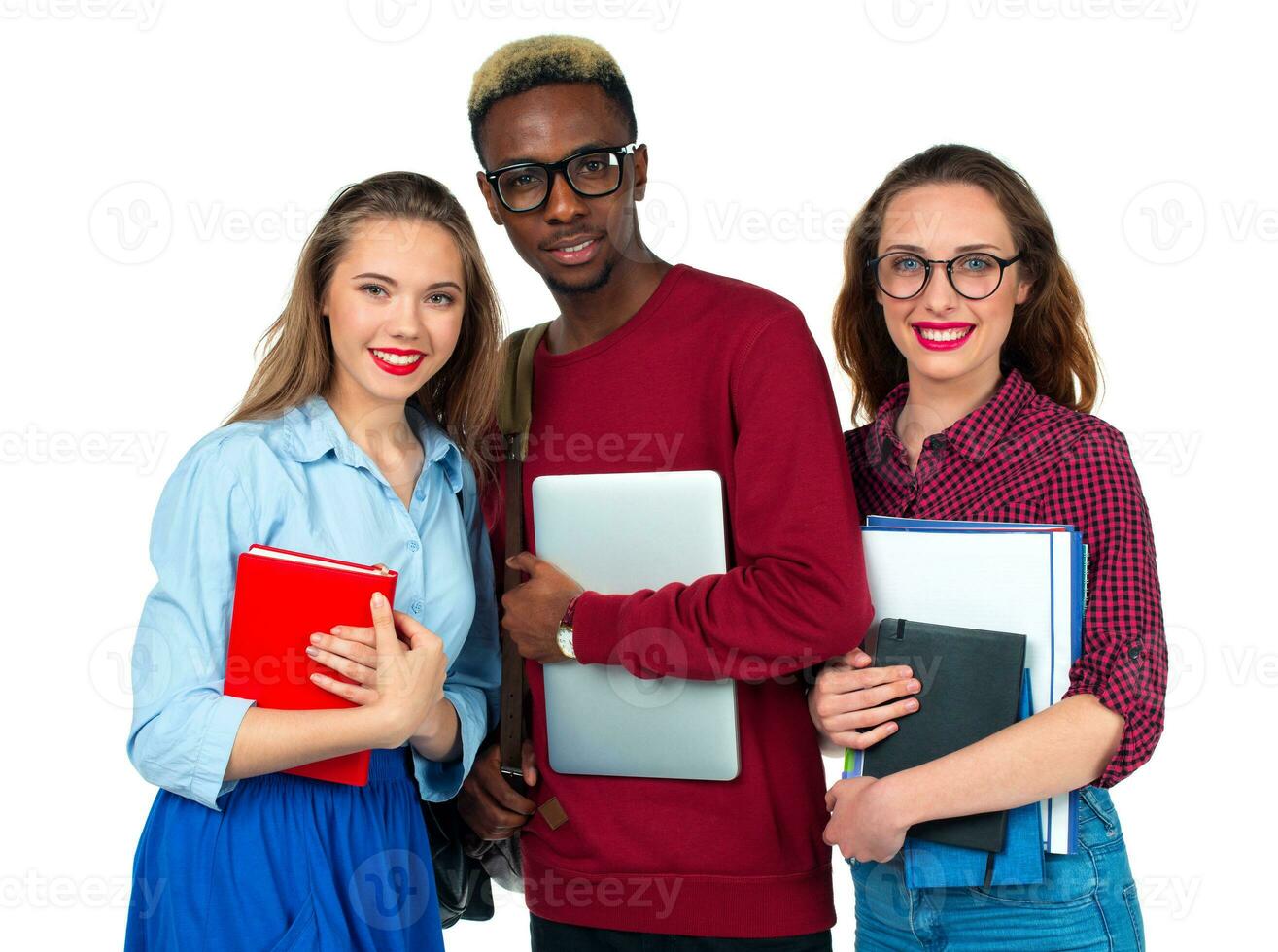 Happy students standing and smiling with books, laptop and bags isolated on white photo