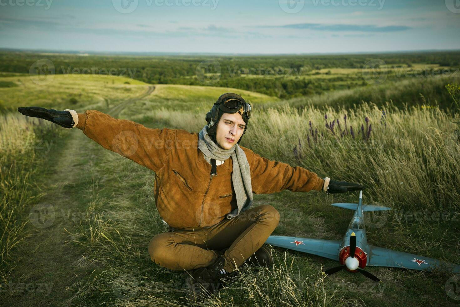 chico en Clásico ropa piloto con un avión modelo al aire libre foto