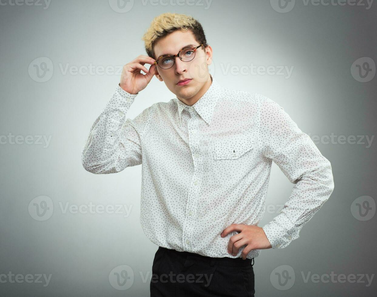 Young serious man looking to the camera wearing glasses photo