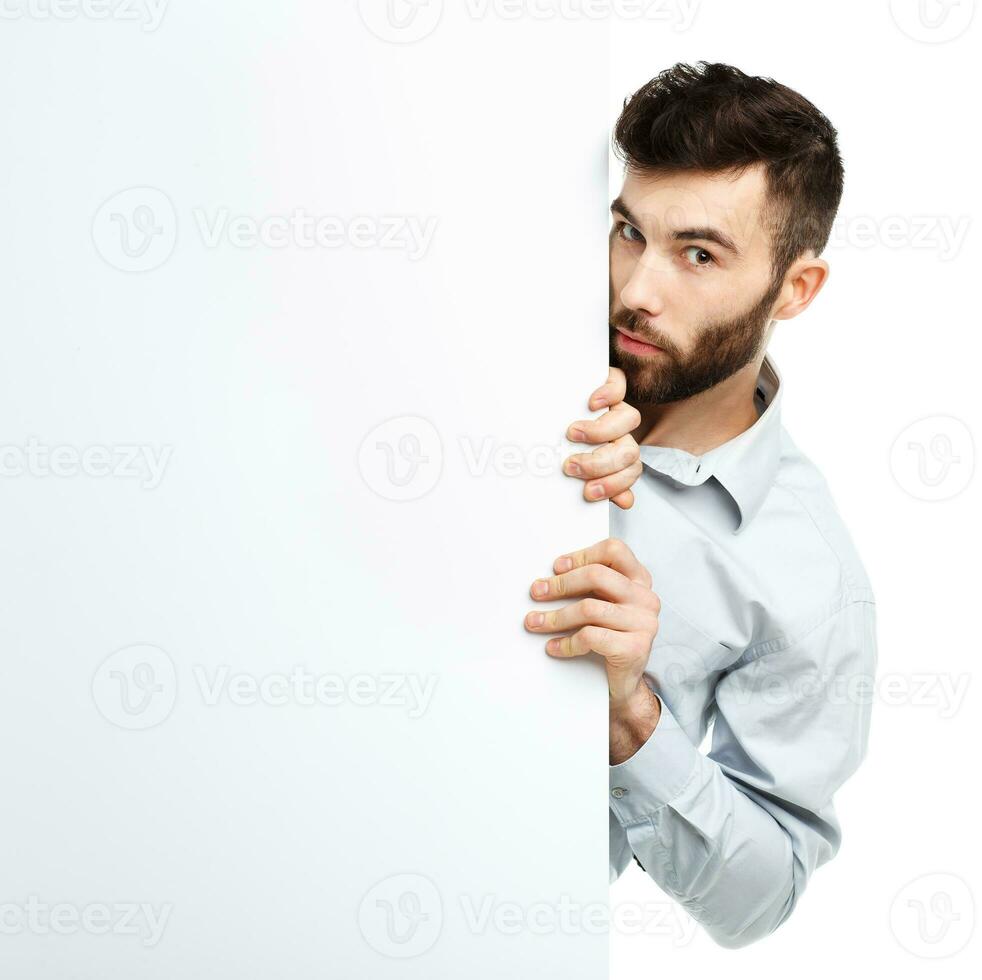 A young bearded man showing blank signboard, isolated over white photo