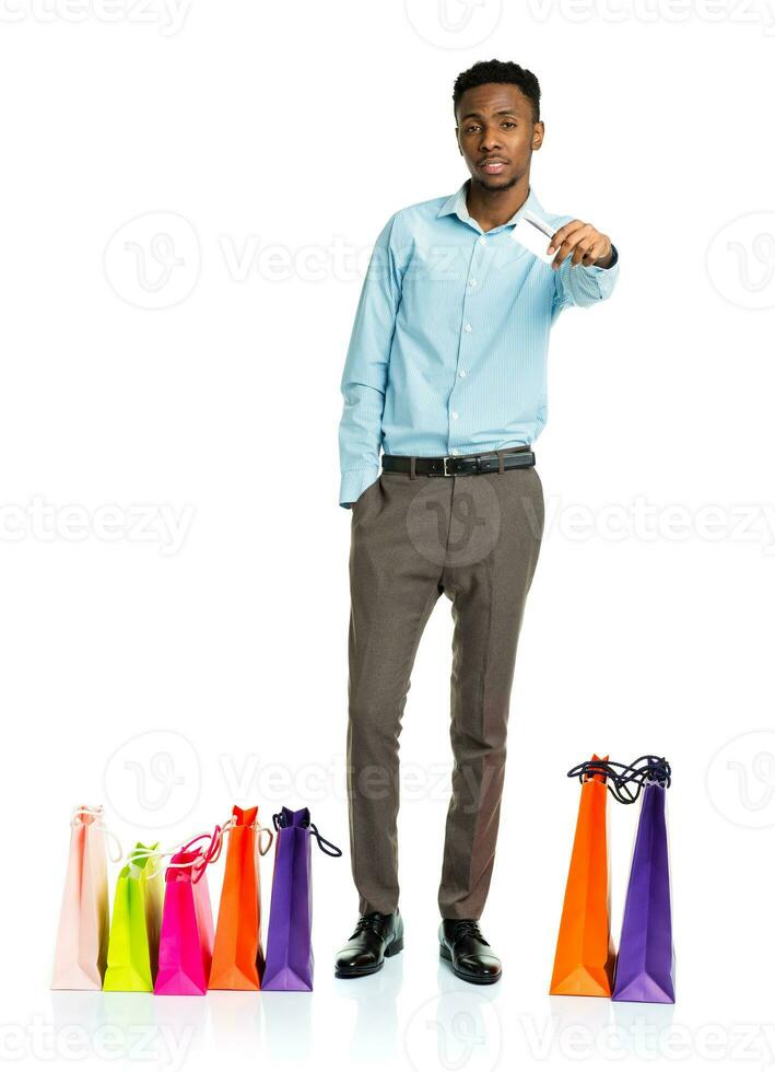 African american man with shopping bags and holding credit card on white background. Shopping photo