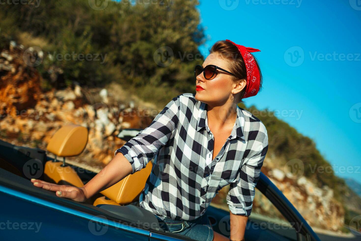 hermosa alfiler arriba mujer sentado en cabriolé, disfrutando viaje en lujo moderno coche con abierto techo foto