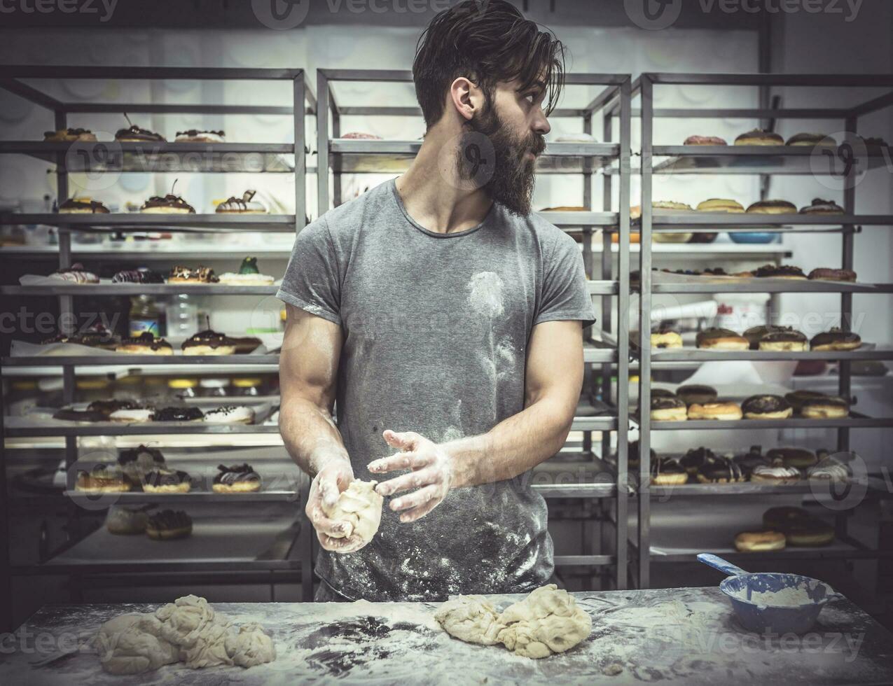 Man in kitchen preparing donuts photo