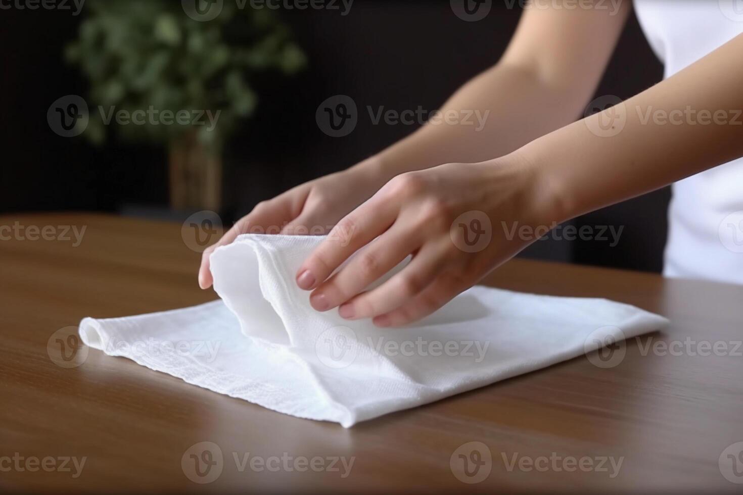 a woman hand holds a white rag over the table. photo