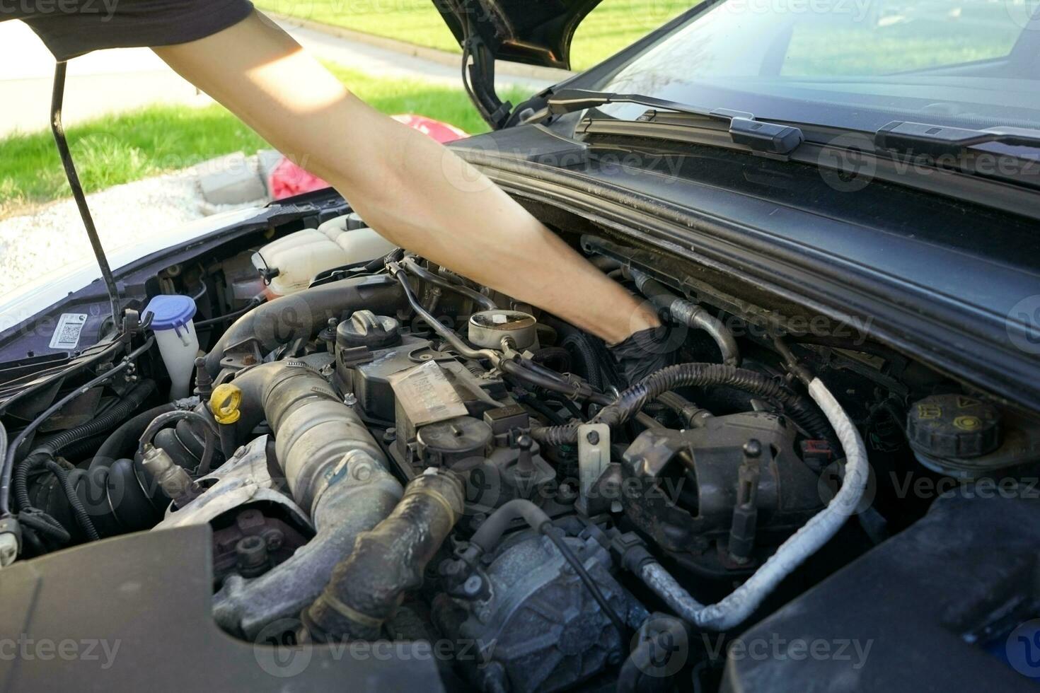 Mechanic checking the engine. Car service, mechanic repairing the engine. Worker inspecting car engine inside. photo