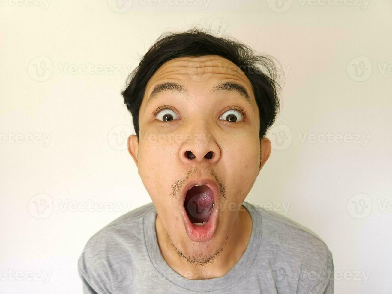 Funny shocked surprised closeup asian face man isolated on white background photo