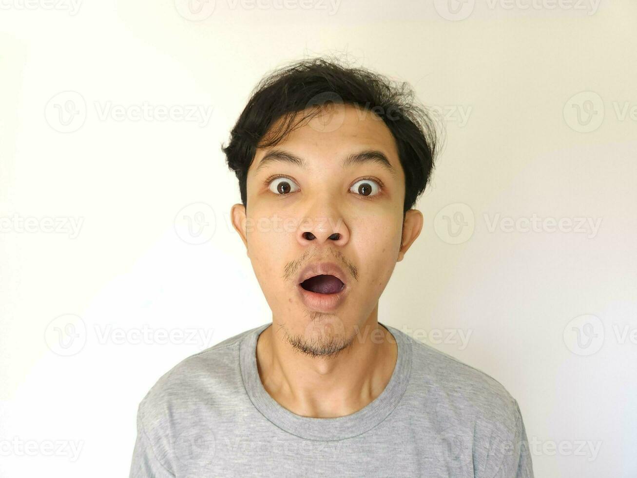 Funny shocked surprised closeup asian face man isolated on white background photo