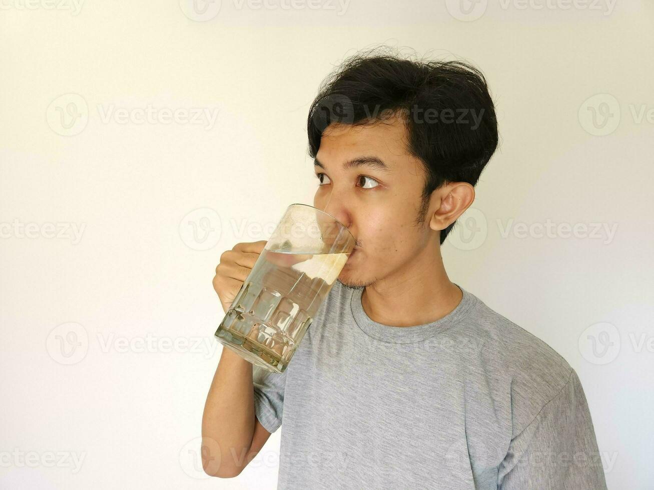 Asian man drinking a glass of water photo