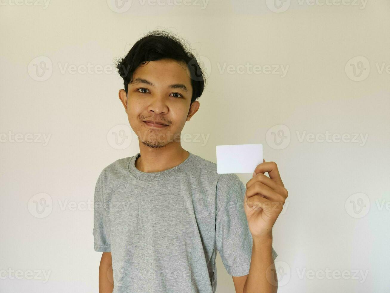 Happy funny face Asian man show off his empty card on white background photo