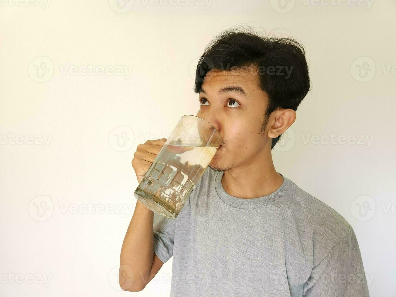 Asian man drinking a glass of water photo