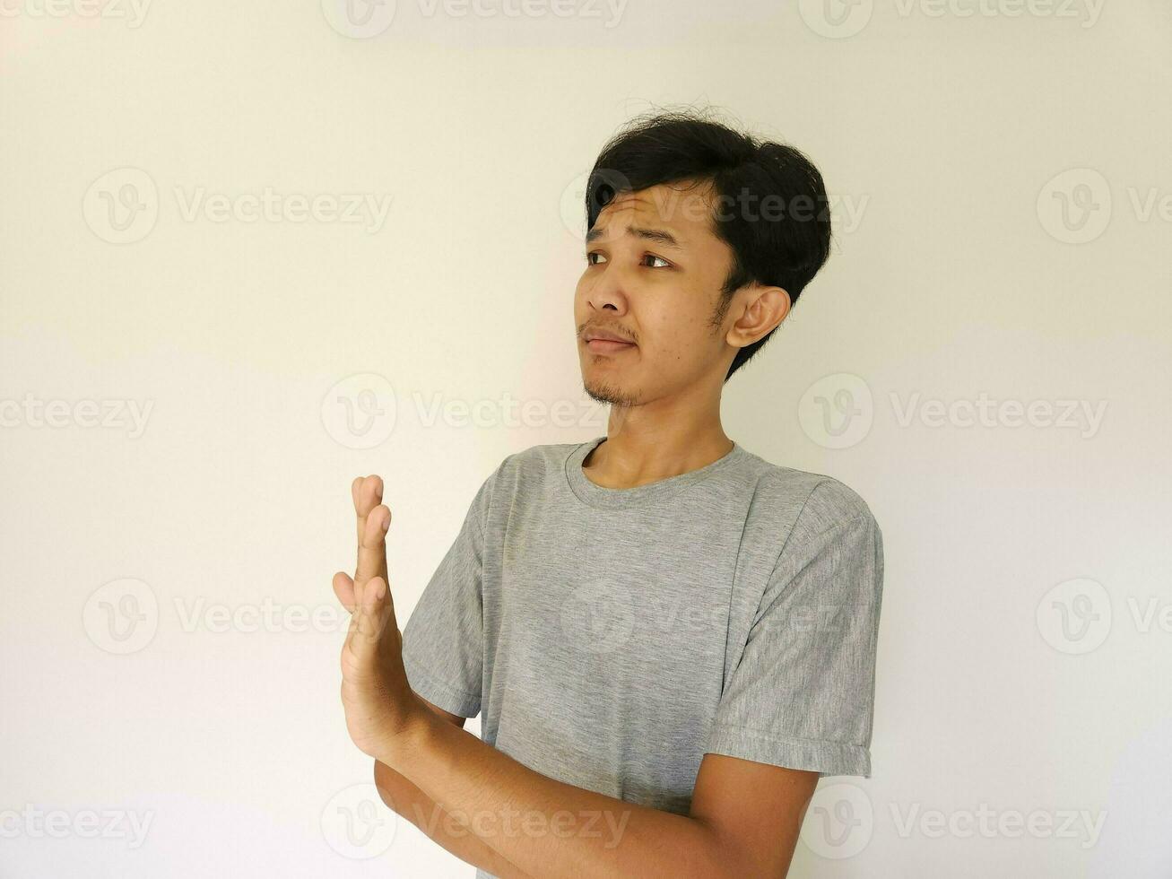 Asian man showing refusal sign, saying no, stop. isolated on white photo