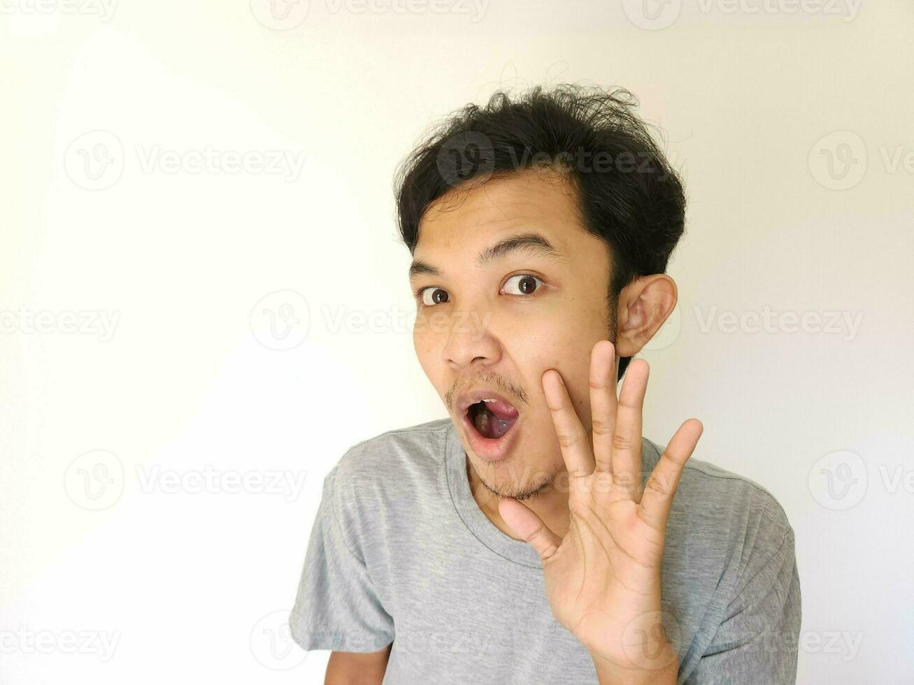 Asian man is whispering some secret gossip isolated on white background. photo