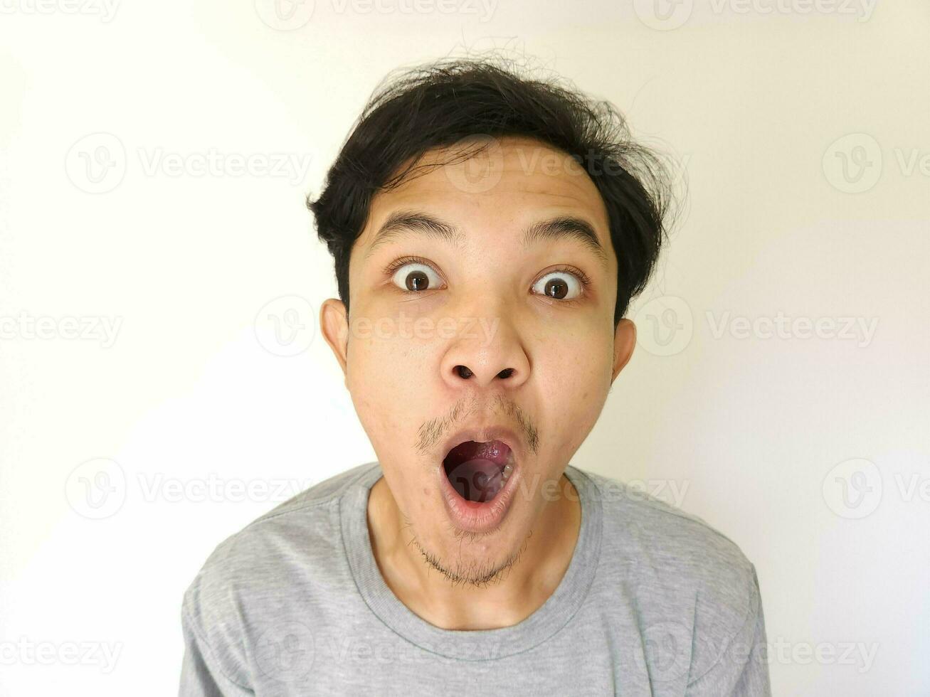 Funny shocked surprised closeup asian face man isolated on white background photo