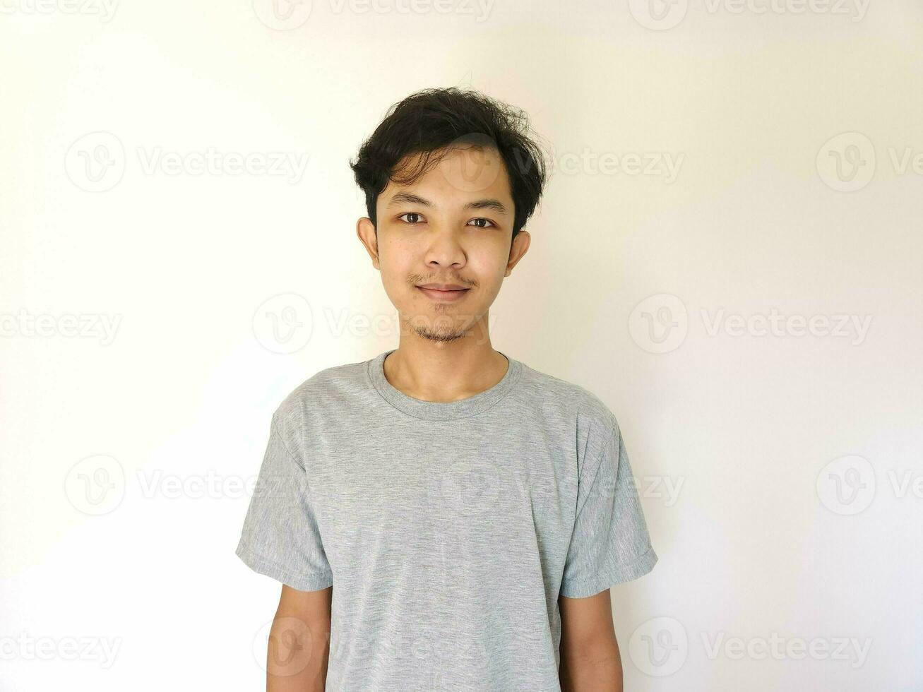 Portrait of happy Asian man in grey t-shirt on isolated white background photo