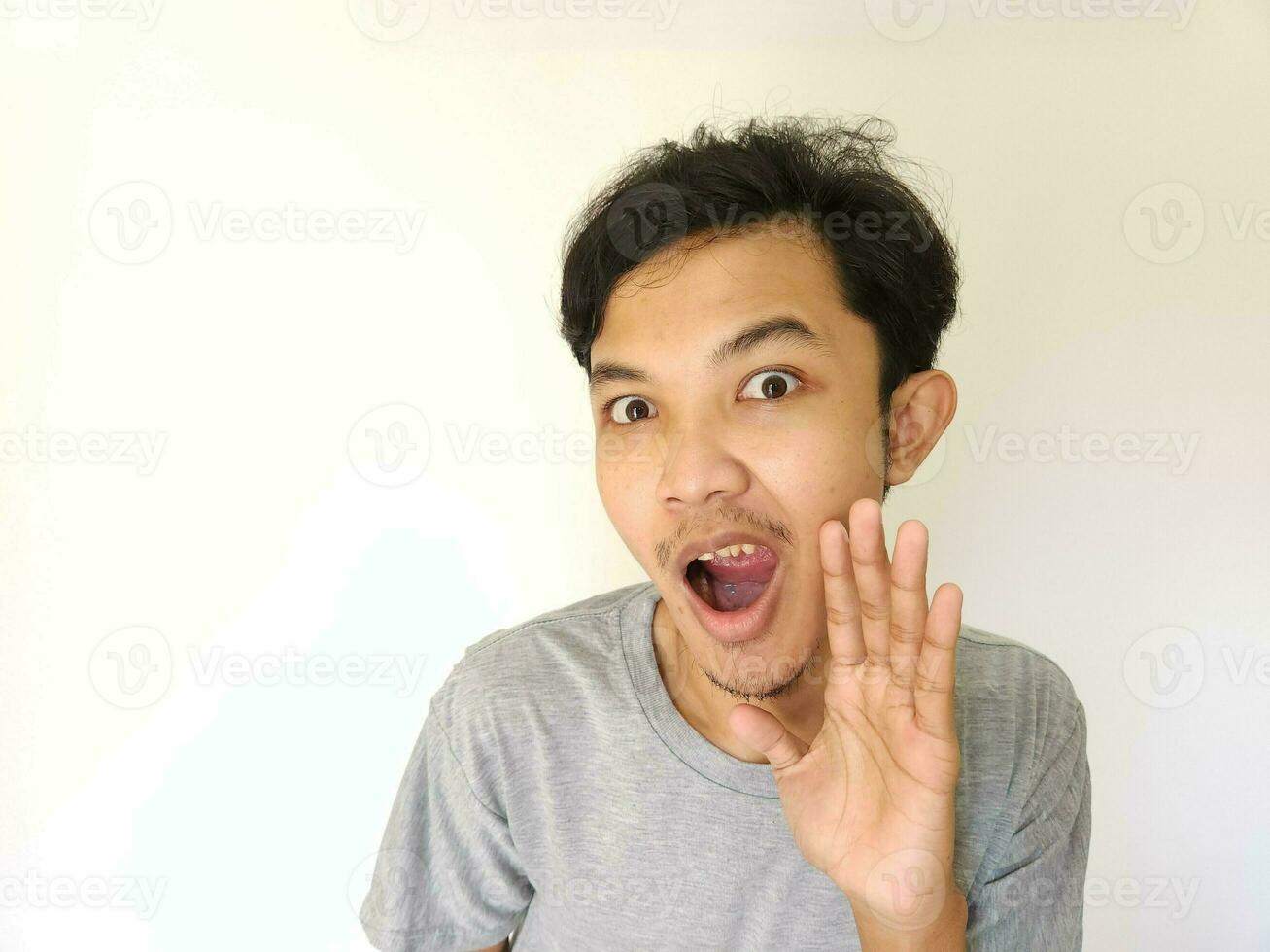 Asian man is whispering some secret gossip isolated on white background. photo