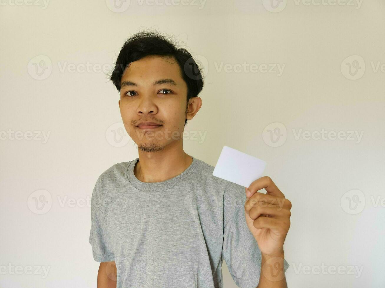Happy funny face Asian man show off his empty card on white background photo