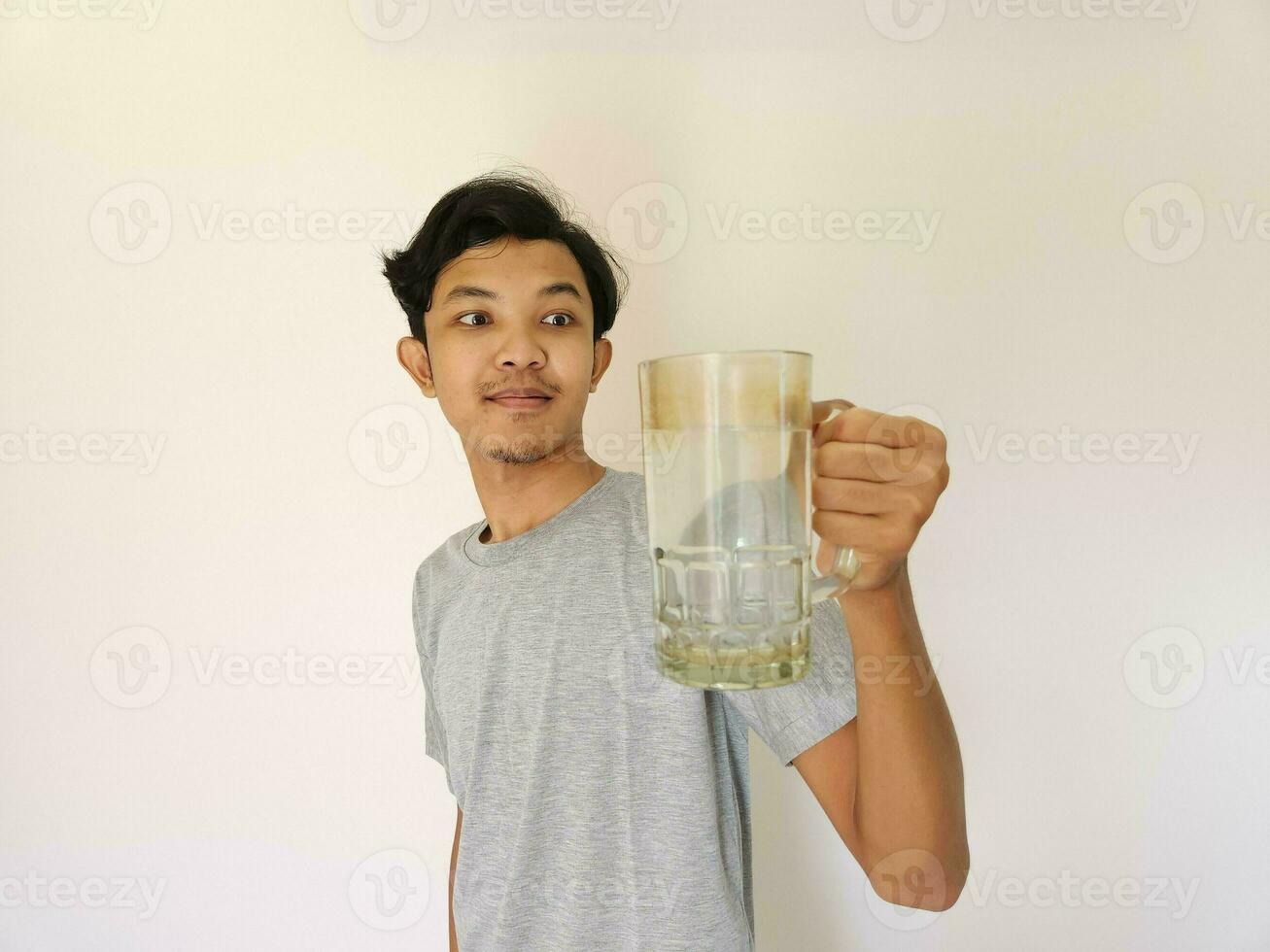 asiático hombre es Bebiendo un vaso de agua y contento foto