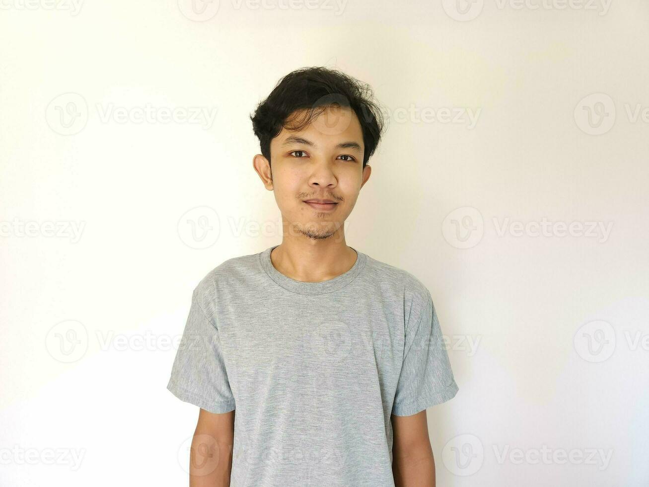 Portrait of happy Asian man in grey t-shirt on isolated white background photo