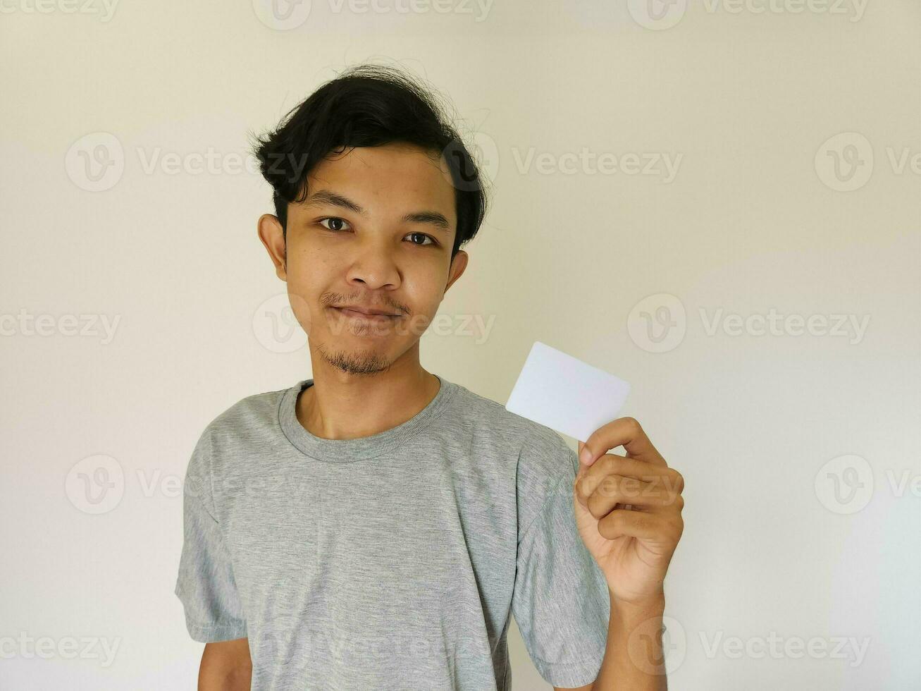 Happy funny face Asian man show off his empty card on white background photo