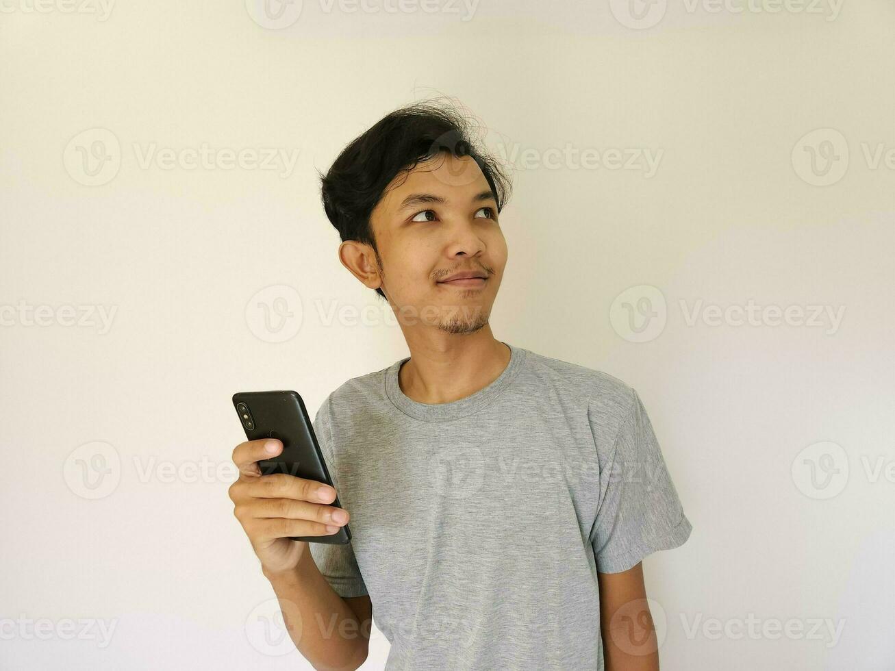 Surprise face asian man use smartphone and facing up with copy space of advertisement photo