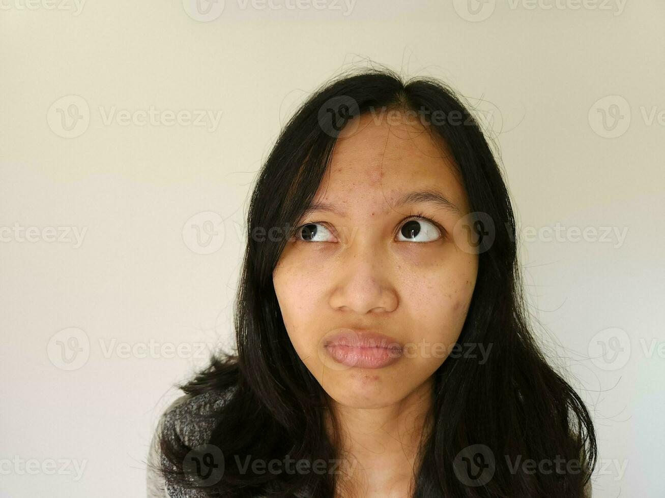 Asian woman worried about acne on her forehead isolated on white photo