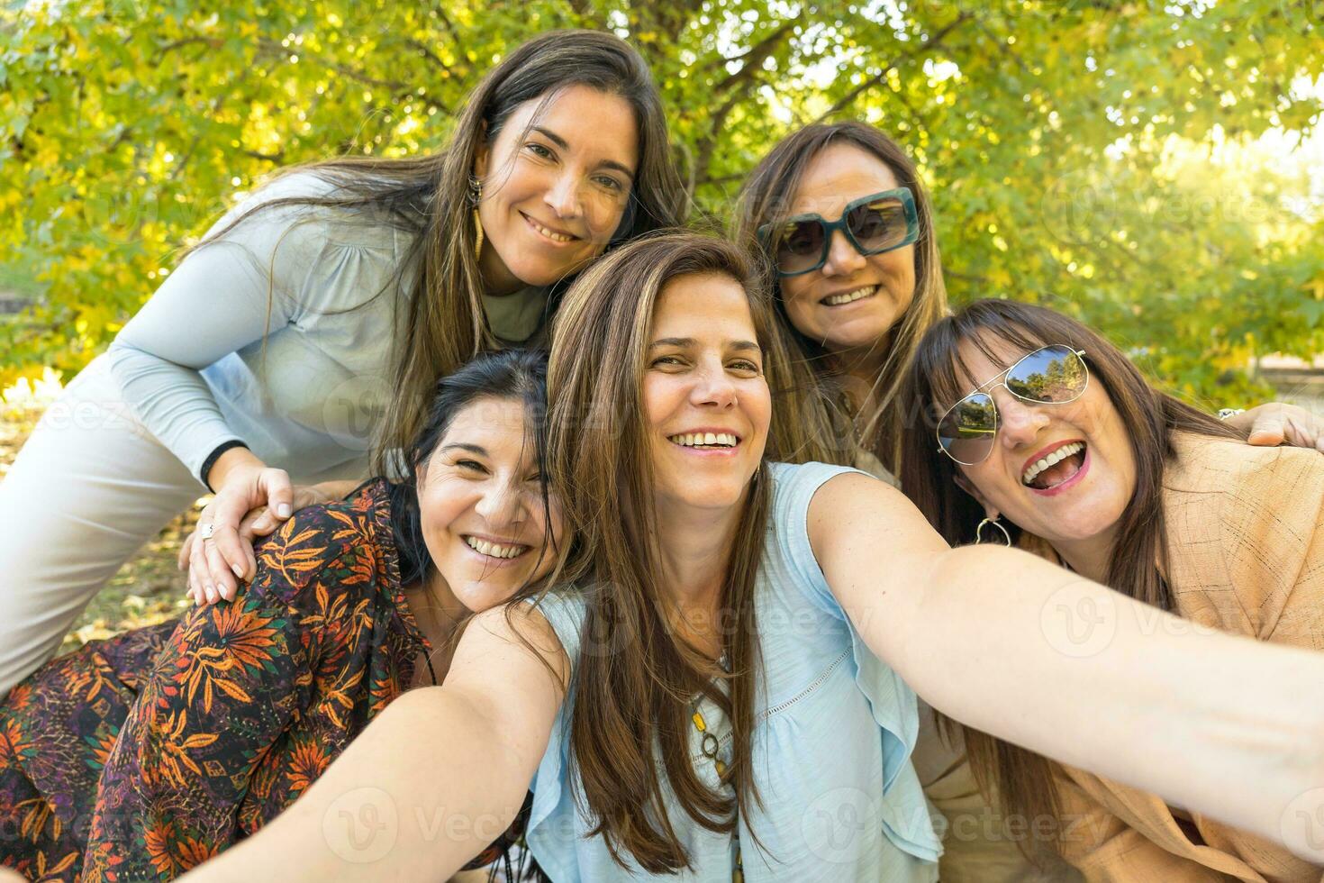 Five cheerful friends in summer clothes taking a selfie. photo